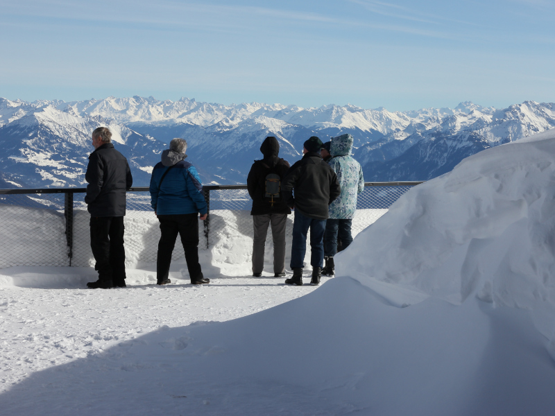 Menschen schauen auf das Vorarlberger Bergpanorama auf dem Europa-Rundweg im Winter